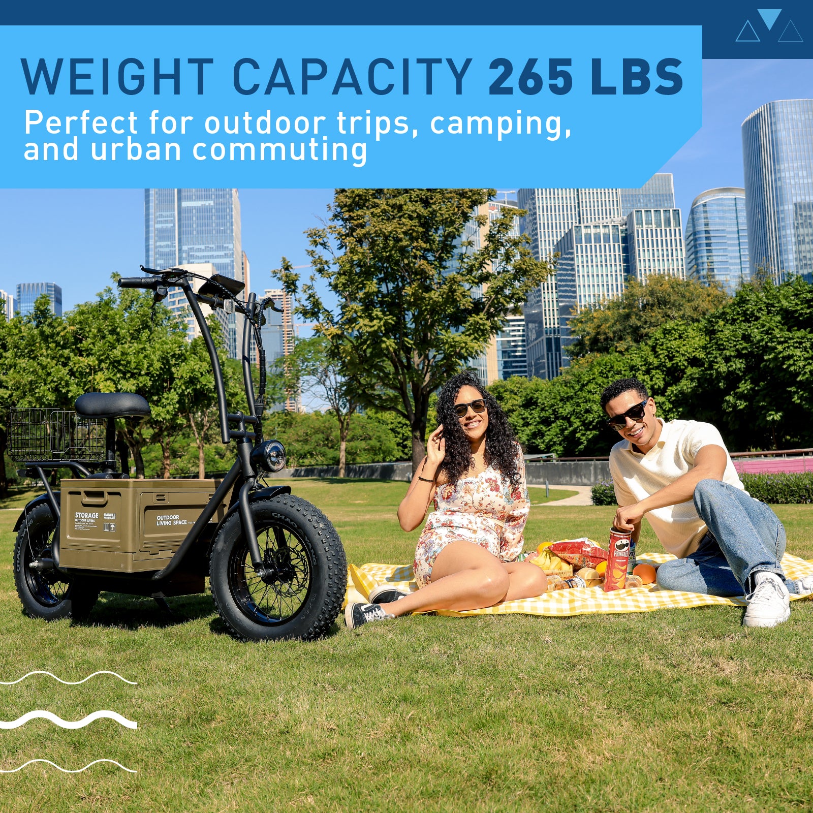 Two people having a picnic with a cargo bike in an urban park setting.